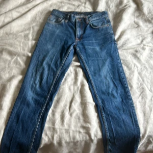 Blå jeans från Nudie Jeans - Säljer ett par snygga blå jeans från Nudie Jeans, modell Gritty Jackson. Storlek 29/32. Bra skick! Något slitna i grenen som bilden visar men inget hål. SKRIV VID FRÅGOR SVARA GÄRNA. PRIS KAN DISKUTERAS VID SNABB AFFÄR!