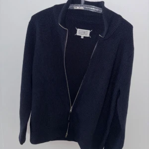 Maison Margiela Cardigan - Mörkblå Maison Margiela Turtleneck Zipper storlek M, har den bästa kvalitén jag någonsin sätt på en kofta, perfekt för hösten/våren. Använt ca 5 gånger. Osäker på autenticitet. Pris kan diskuteras vid SNABBKÖP
