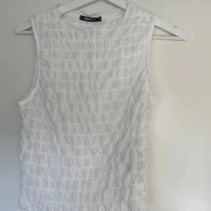 Vit topp från Gina tricot  - Säljer en stilren vit topp från Gina tricot. Perfekt för varma dagar eller som ett lager under en jacka.