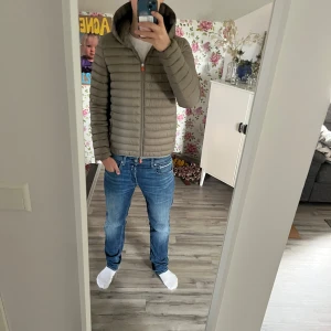 Beige pufferjacka från Save the Duck - Säljer en snygg beige pufferjacka från Save the Duck. Jackan har en dragkedja framtill och en mysig huva. Den är quiltad och har en cool logga på ärmen. Perfekt för kyligare dagar! Jätte bra kvalité och absolut toppskick🕺. Nypris  2200. Mitt pris 1099💵. ‼️ Priset inte hugget i sten‼️