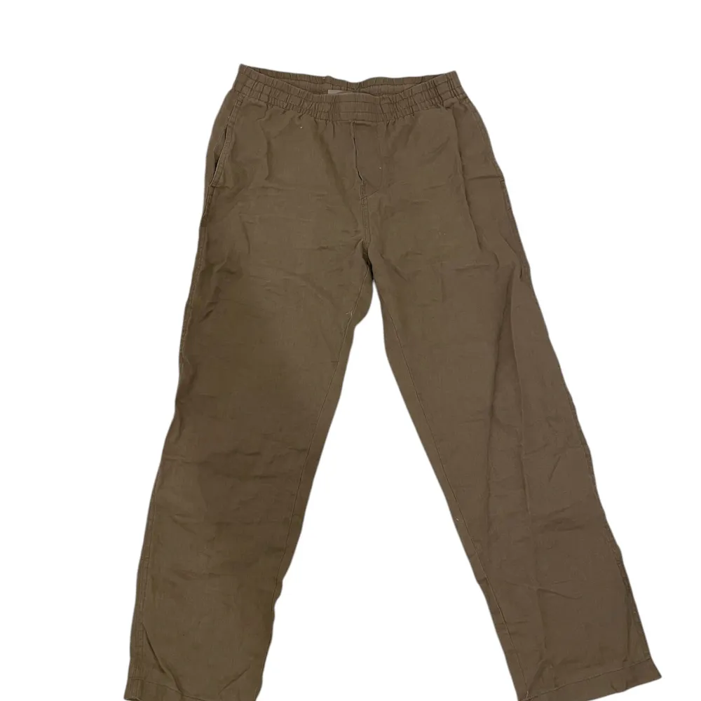 Säljer ett par bekväma beiga linnebyxor från H&M med resårmidja. Perfekta för en avslappnad stil. Byxorna har en rak passform och är tillverkade i ett 100% linne material. . Farkut & Housut.