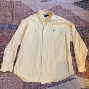 Ralph Lauren skjorta - En snygg och stilren skjorta från Ralph Lauren i ett väldigt bra skick förutom en liten fläck som man kan få bort hyfsat enkelt (se bild 5). Hör av dig vid eventuella frågor eller funderingar!