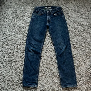 Mörkblå jeans från Karve - Snygga mörkblå jeans från Karve med en klassisk straight passform. De har en midwaist design och är tillverkade i jeansmaterial. Perfekta för en stilren look.