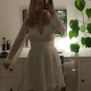 Vit klänning, studentklänning  - Elegant vit klänning med v-ringning och långa ärmar i ett lätt och flödande material. Perfekt för somriga tillfällen och framför allt som skolavslutning/ studentklänning. Älskade denna på min student, kände mig bekväm och snygg. Bakom knyter man ett band i midjan som gör att den går att göra mer eller mindre figursydd. 🤍🥳Perfekt att fynda en fin klänning till en väldigt redan dyr dag🤩