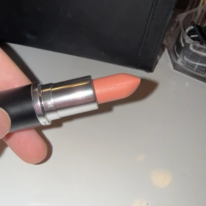 MAC Satin Lipstick i nyansen Myth - MAC Satin Lipstick i nyansen Myth, en mjuk och krämig läppstift med en ljus nude färg. Perfekt för en naturlig look. Kommer i en elegant svart hylsa med silverdetaljer. aldrig använd