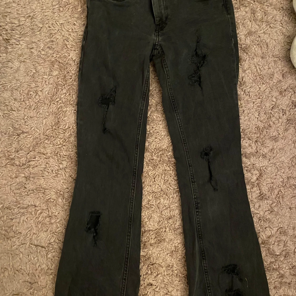 Svarta jeans med slitningar