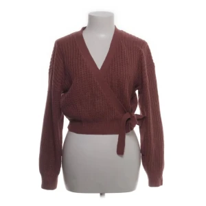 Brun omlottkofta från ONLY - Säljer en snygg brun omlottkofta från ONLY. Den är stickad med en knytning i midjan och har långa ärmar. Perfekt för att hålla sig varm och stilren under kyligare dagar. Passar bra till både jeans och kjol.