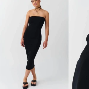 Svart tube klänning - Snygg svart axelbandslös klänning i tight passform. Perfekt för en elegant look med sin enkla och stilrena design. Klänningen är knälång och passar utmärkt för olika tillfällen.