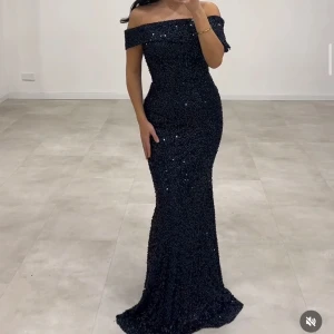 Svart glittrig långklänning - Elegant svart långklänning med glittrande paljetter och offshoulder-design. Ny med prislapp. Perfekt till balen 😍Köpte den från insta sidan @Laselins, nypris 3000kr men passade inte mig tyvärr. 