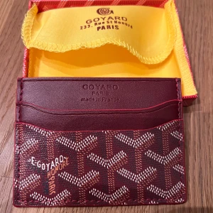 Vinröd Plånbok / korthållare slim - Det är en vinröd plånbok som är slim. Passar både tjejer och killar och passar rakt i fickan. Helt ny aldrig använd. Lådan och kortet får man med😁 finns det frågor så är det bara att fråga på