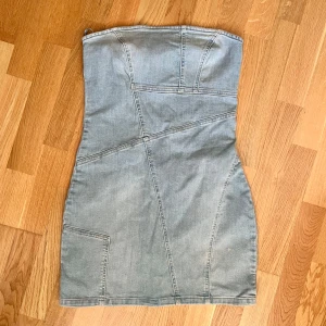 Jeansklänning - Denim bandeau dress i ljusblå färg och med mönster! Klänningen är i mini-längd och går till mitten av låret! Plagget är i nyskick, har aldrig använts och har prislappen kvar. Det är bara att skriva om du har några frågor! <3 