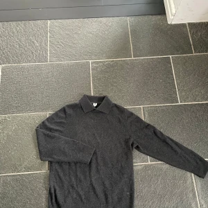 Mörkgrå kashmirtröja från Arket - Säljer en elegant mörkgrå kashmirtröja med krage. Tröjan är perfekt för Våren eller för att få en Grisch stil🥶Det är bara att fråga på🤑