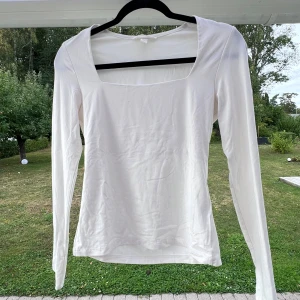 Vit långärmad topp - En vit långärmad topp med fyrkantig skärning, från H&M 🤍 Toppen är i ett väldigt mjukt material och sitter bra på mig som är en S. Dubbelt tyg vid brösten, så ingen bh behövs ☀️🙌🏻  Använd max 3 gånger!  Längd: 50 cm Axel: 36 cm