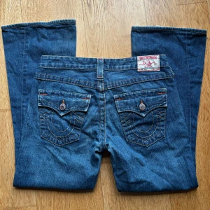 True Religion Jeans - Jätte söta lågmidjade trueys i storlek 29. De är lite slitna längst ner vid hälen (bild 3 ) men utöver så är de i fint skick. Midjemåttet rakt över är 39cm och innerbenslängden är 68cm ☺️💞 Skriv privat för frågor