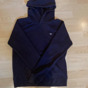 Gant hoodie mörkblå - Jag säljer min sons tröja då han vuxit ur den. Den är i gott skick & passar 13-14år. 