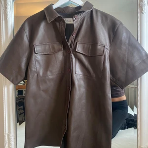 Skjorta - Kort ärmad skjorta i skinnimitation från NA-KD 🍂