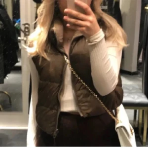 ZARA dunväst - Säljer en snygg brun dunväst från Zara!!🤎 Den är gjord för att kunna använda den ut och in! så två västar i en!!🤎Använts fåtal gånger🤎