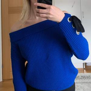 Off-shoulder topp i jättefin blå färg med svarta detaljer i ärmarna. Använd ett fåtal gånger