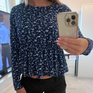Tröja med volang  - Superfin mörkblå tröja med små blommor och volang längs ner i storlek Xs:)