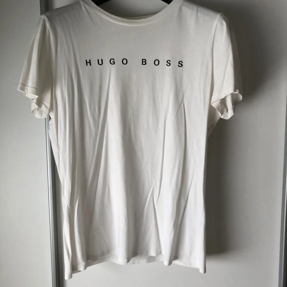 Säljer en vit t-shirt från Hugo Boss. Den har korta ärmar. Perfekt för en avslappnad och snygg look. Hugo Boss-loggan är tryckt både fram och bak på tröjan. Knappt använd. T-shirts.