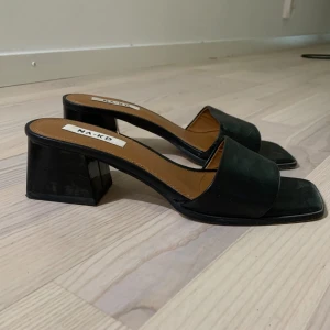 Svarta klackskor från NA-KD - Säljer ett par stilrena svarta klackskor från NA-KD. De har en fyrkantig tå och en bred rem över foten. Klacken är stabil och ger en modern look 🖤