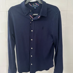 Ralph Lauren skjorta  - ett riktigt fräsh raffe skjorta i riktigt skönt material ( bomull). är strlk 14-16y men är som herr xs, är använd väldigt få gånger( är som ny)! köpt för ca 1500kr hör av er vid frågor&bilder!🤝🏽🙌🏽