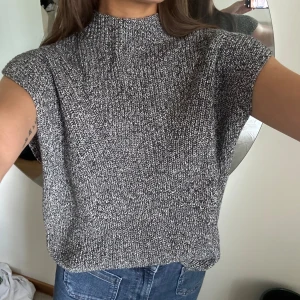 Stickad väst Massimo dutti  - Kortärmad stickad från Massimo dutti. Köpt våren 2024, skicket är som ny! Använd 1 gång.  Superfint grå/vitt garn är den stickad i.  Mjuk och skön. Snygg att ha över en långärmad tröja eller skjorta också. Ser lyxig ut! Kostade 500