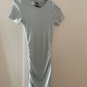 BLÅ SOMMARKLÄNNING - Säljer denna ljusblå tighta sommarklänningen från H&M. Använd måttligt. 