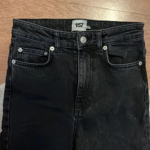 Svarta jeans från 157 - Snygga svarta jeans från 157 i storlek S. De har en klassisk femficksdesign och en slitsdetalj vid bensluten. Perfekta för en stilren look. Dom är aldrig använda köpte dom för små