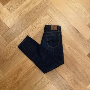 Nudie Jeans - Mörkblå  - Säljer nu ett par Nudie jeans då de var för små för mig. De har en slim/straight fit och en schysst mörkblå wash.  Storleken är 34/32 men är lite mindre. Skriv vid fler frågor!