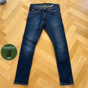 Mörkblå jeansbyxor från Lee - Snygga mörkblå jeansbyxor från Lee med en klassisk femficksdesign. Byxorna har en slim passform och är tillverkade i slitstarkt denim. Perfekta för en stilren look. ❄️☀️storlek 31/30