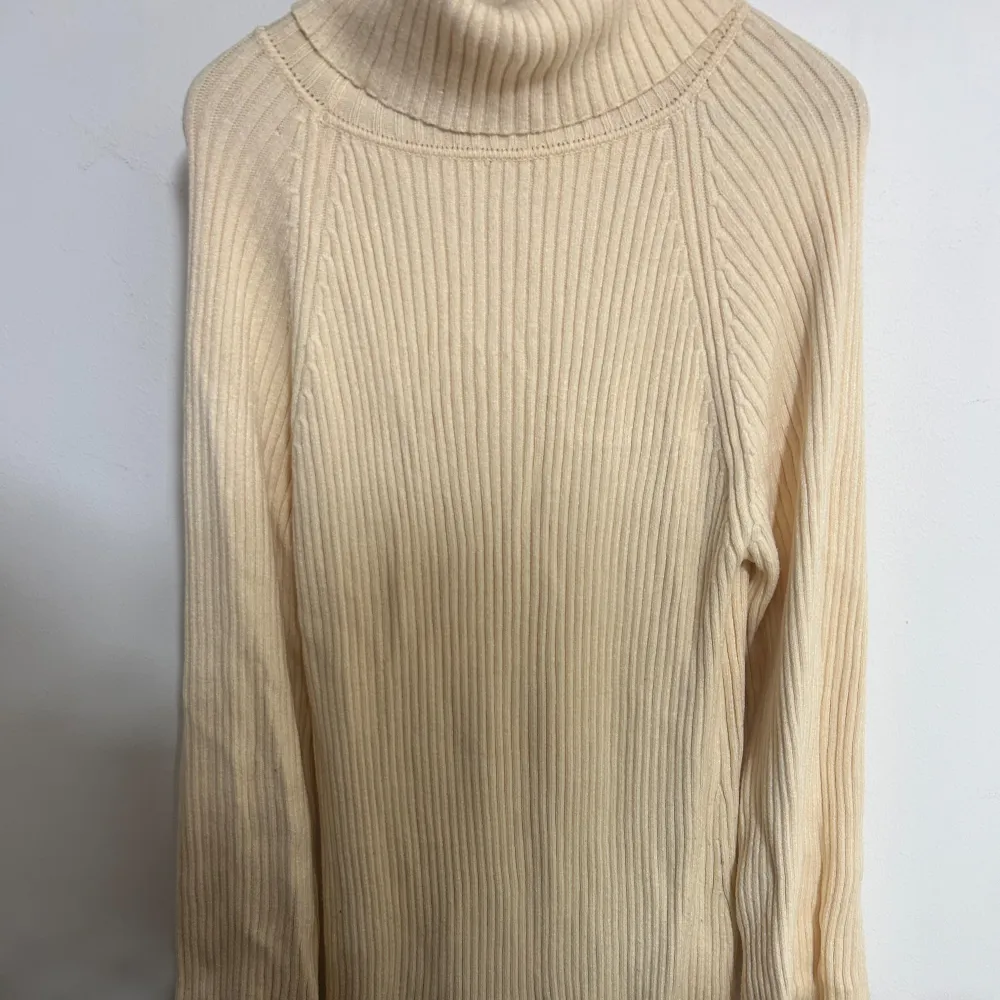 Säljer en stilren beige polo klänning med ribbad struktur. Klänningen har långa ärmar och en hög polokrage som ger en mysig känsla. Den är midi lång . Mekot.