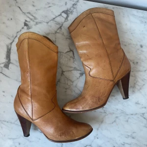 Bruna skinnstövletter med klack - Snygga bruna stövletter i skinn med en elegant klack. Perfekta för en stilren look. De har en klassisk design med rundad tå och är tillverkade i högkvalitativt material.