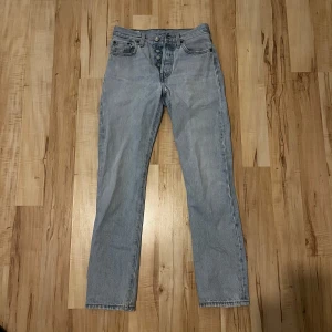 Ljusblå jeans från Levi's - Snygga ljusblå levis 501 med knappar i gylfen. Klassisk design med fem fickor och raka ben. Perfekta för en avslappnad stil. W24 L30