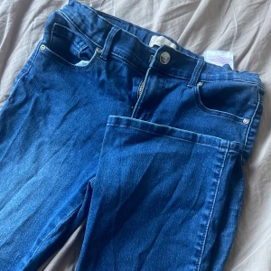 Blå jeans från Kids Only - Snygga blå jeans från Kids Only i storlek 152. Klassisk design med fem fickor och knappgylf. Perfekta för en avslappnad stil. Utsvängda 