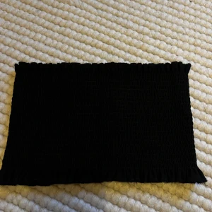 Svart smockad tub topp. - Svart smockad bandeau topp från Gina tricot.