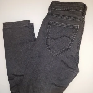 Svarta jeans från Lee - Snygga svarta jeans från Lee med klassisk femficksdesign. Passformen är normal och de är tillverkade i ett slitstarkt material. Garderobsrensning så kika gärna på övriga auktioner.