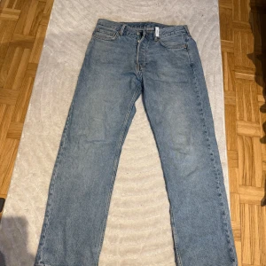 Blå jeans från Weekday - Säljer ett par klassiska blå jeans från Weekday. De har en rak passform och är tillverkade i denim med en dragkedja och knapp framtill. Perfekta för en avslappnad stil. W30 L30