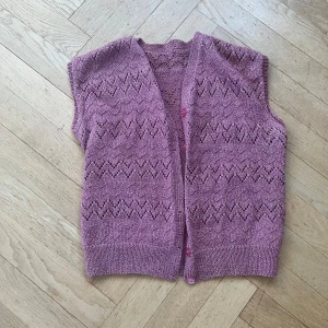Rosa stickad väst - Säljer en söt rosa stickad väst med ett fint mönster. Västen har en v-ringad design och knappar framtill. Perfekt för att lägga till en extra touch till din outfit. Priset kan diskuteras💕🥰