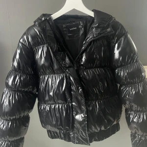 Svart glansig pufferjacka från Boohoo - Snygg svart glansig pufferjacka från Boohoo.  Knappt använd.