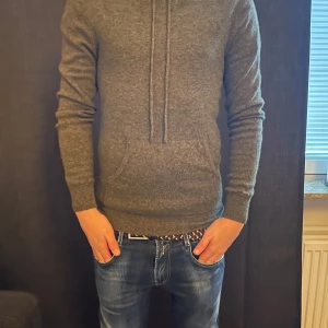 Mörk grön kashmir hoodie ifrån John henric  - Säljer en stilren mörk grön kashmir hoodie med lång ärm och praktisk ficka framtill. Perfekt för en avslappnad look. Den har en bekväm passform och är tillverkad i ett mjukt material. Passar perfekt till alla årstider och en fin detalj till en sen sommarkväll                    Köpt ifrån John Henric och använd ca 5 gånger, kashmiren är 10/10 och vid frågor skriv dm! 