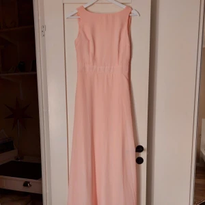 Ljusrosa klänning - Ljusrosa klänning från Boohoo Occasion. Köpt för några år sedan men aldrig kommit till användning. Klänningen är väldigt lång och perfekt som balklänning! 💞 På första bilden är klänningens framsida och på andra bilden är klänningens baksida. Klänningen är i storlek 32