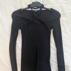 Svart tröja  - Snygg svart ribbad tröja med snörning runt halsen om man så vill. 