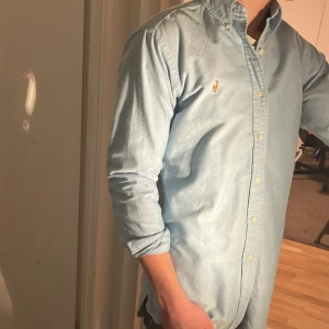 Ralph Lauren Skjorta - Tja säljer en Ralph lauren skjorta i färgen ljusblå och i storlek S passar 170-180 cm ungefär. Nypris 1595 KR mitt pris 299 KR. Inga defekter som hål eller fläckar. Skriv vid frågor eller funderingar.