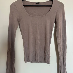 Beige långärmad topp - beige långärmad topp med rund halsringning. Slits i armarna. Använd men bra skick.