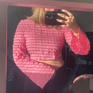 Rosa croppad topp - Säljer en söt rosa croppad topp med långa ärmar och knytning baktill, mycket bra skick endast använd 1-2 gånger 💕💕