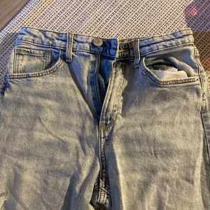 Ljusa jeans med vida ben och hög midja från H&M - Snygga ljusa jeans från H&M med vida ben och hög midja. De har justerbar midja och klassiska femficksdetaljer. Perfekta för en avslappnad stil. Oanvända 