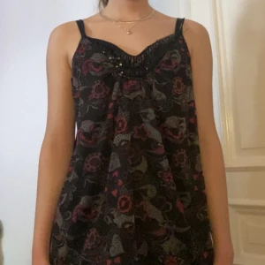 fin topp - fin topp med paljetter. storlek M men passar s-l beroende på hur man vill att den ska passa, har dessutom justerbara band. köpt secondhand. den slutar ungefär där bilden slutar 