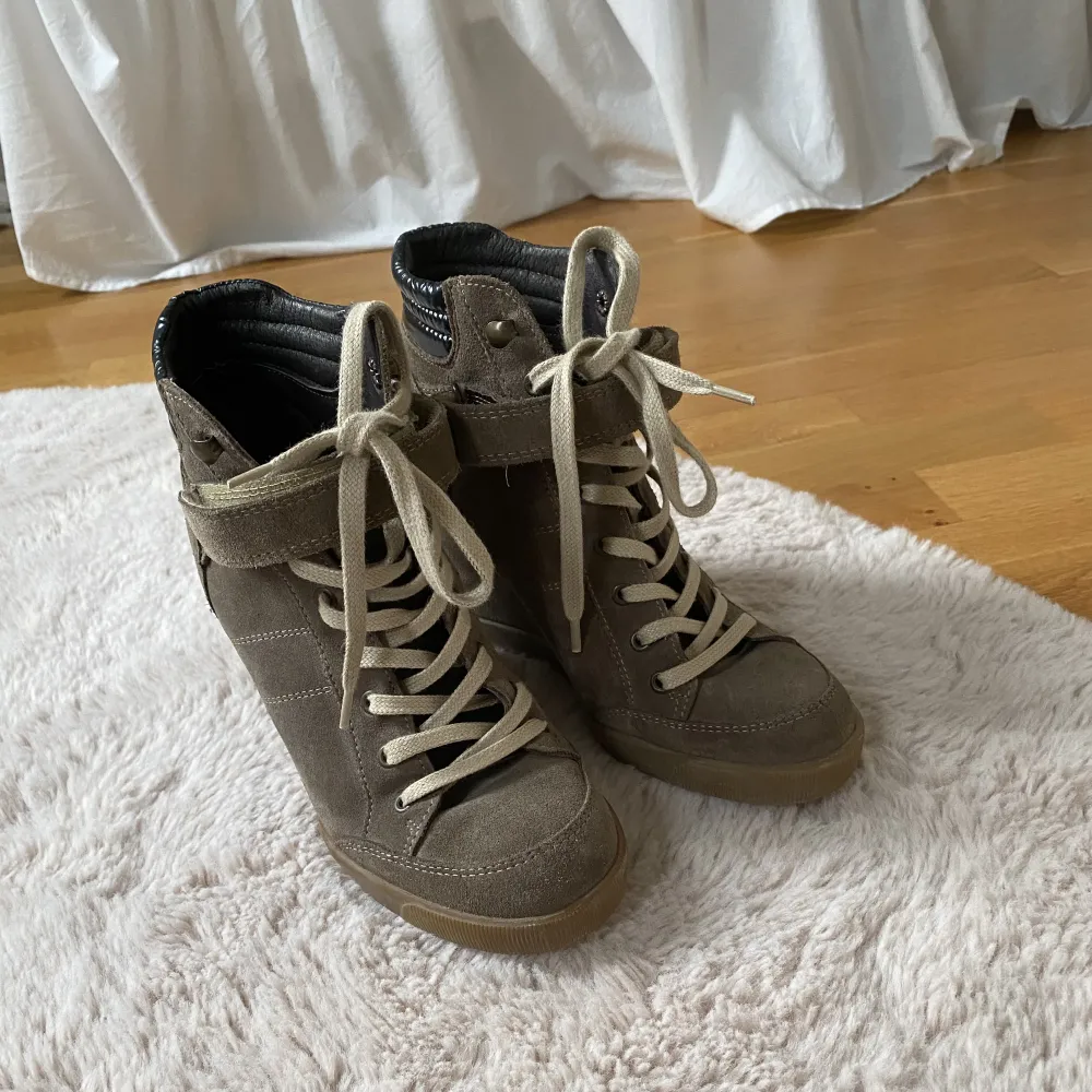 Ett par skor med kilklackar som är lite liknande isabel markant skorna. De är i en brun färg. Ny pris runt 1400kr. Skor.