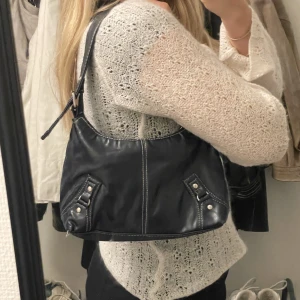 Handväska - Jättesnygg axelväska, köpt second hand men kommer tyvärr inte till användning.  Den är mörkblå men ser svart ut när den inte är i direkt dagsljus